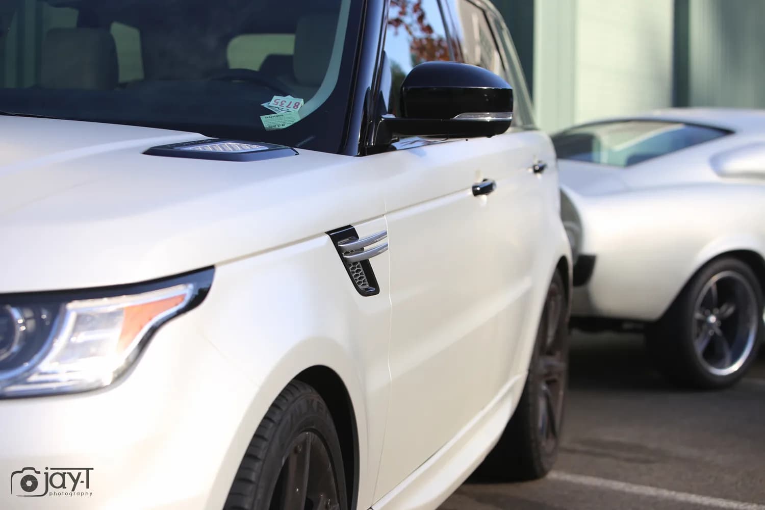Front quarter detail of a Range Rover Sport wrapped in satin pearl white